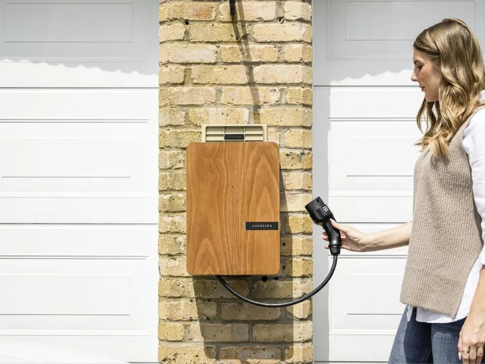 Level 2 EV charger mounted on a garage wall next to an electric vehicle charging port